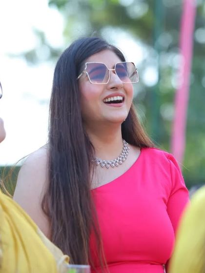 A candid shot of a guest enjoying the outdoor birthday party. Her bright pink dress and happy expression add to the festive mood of the day.