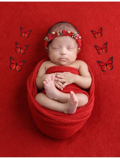 A simple red swaddle portrait enhanced with butterfly details. This shows how a small digital addition can add a touch of magic to a classic photo.