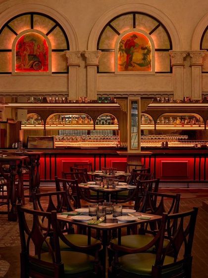 The main dining area and bar at Los Cavos, with its striking red backlighting. The space is designed to transport you to Cuba, blending Portuguese architectural elements with a vibrant, energetic mood.