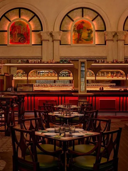 The main dining area and bar at Los Cavos, with its striking red backlighting. The space is designed to transport you to Cuba, blending Portuguese architectural elements with a vibrant, energetic mood.