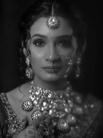 A striking black and white bridal portrait. The intense gaze and the detailed jewelry create a powerful and captivating image that is both modern and timeless.