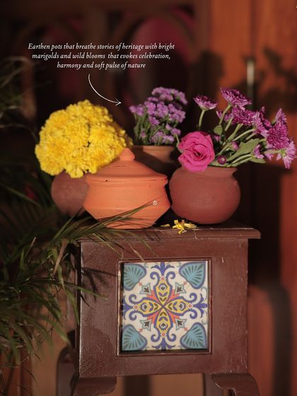 An annotated image highlighting the use of earthen pots with marigolds and wild blooms, evoking a sense of heritage and natural harmony.