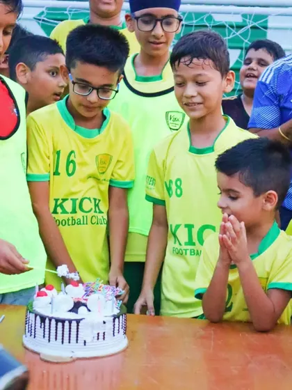 A young player makes a wish before blowing out the candles on his birthday cake.