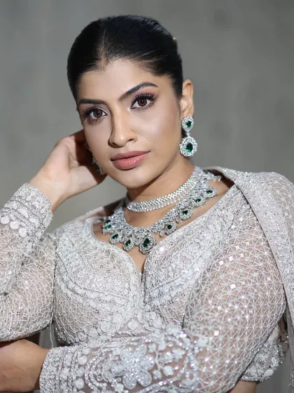 A close-up of our popular emerald and zircon layered necklace. Paired with an elegant white chikankari outfit, this set is perfect for a sophisticated daytime event or reception.