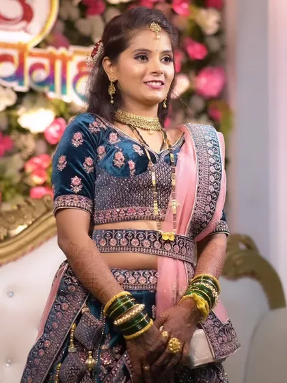 A beautiful reception look in a deep teal and pink lehenga, with makeup that is both elegant and striking.