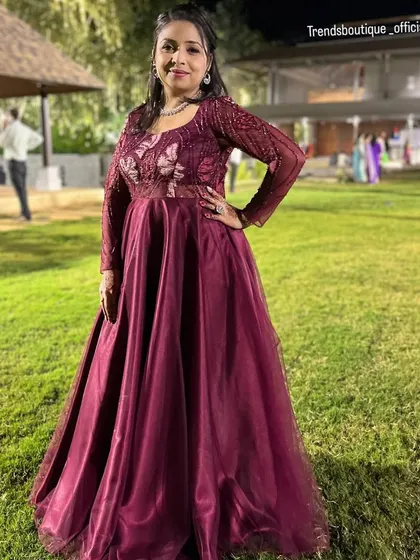 Beyond traditional wear, I also design and stitch elegant gowns for receptions and parties. This client is wearing a custom wine-colored gown with delicate butterfly embroidery on the sheer bodice.