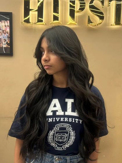 A client with a fresh haircut, featuring long layers and soft waves that boost confidence and style.