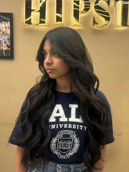 A client with a fresh haircut, featuring long layers and soft waves that boost confidence and style.