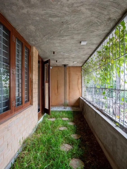 We designed this narrow, open-to-sky passage to bring a strip of nature right into the home. This biophilic design element acts as a green lung for the house, improving air quality and providing a constant visual connection to the outdoors.