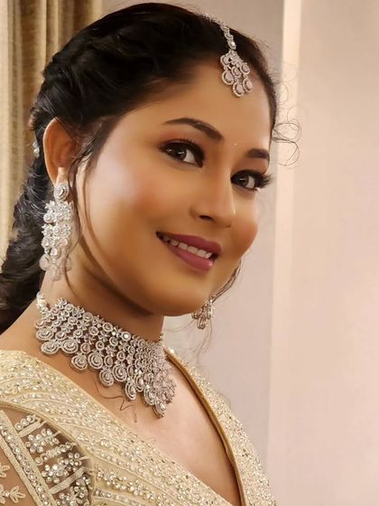 A happy bride wearing a simple American diamond choker. It's an elegant choice that doesn't overpower her look.