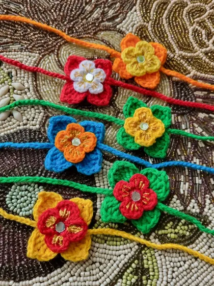 A colorful assortment of our small flower rakhis. Each one is crafted with a mirror work center for a little bit of sparkle.