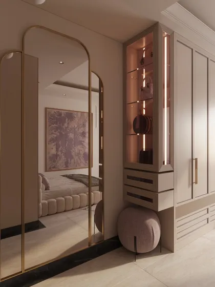 A full-length arched mirror and a lit display niche are cleverly integrated into the wardrobe unit, blending function with beauty.