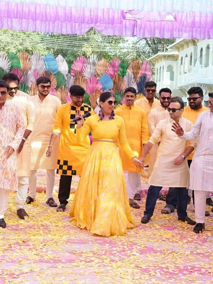 Leading the groom's squad in a synchronized dance move. Haldi ceremonies are the perfect time for some lighthearted, fun group activities.