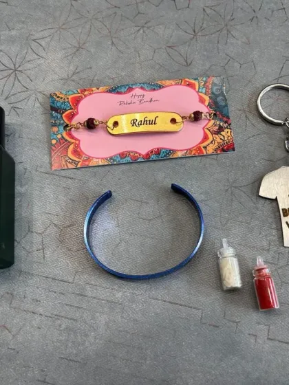 This Rakhi combo includes a personalized perfume, a stylish half-kada, a "Best Brother" keychain, and a Rudraksha rakhi, available in four different kada colors.