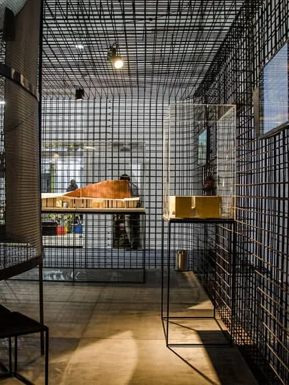 For an exhibition at India Arch Dialogue, we used black steel mesh to create porous, transparent walls. This material choice defines the space without creating solid barriers, allowing for visual connection throughout.