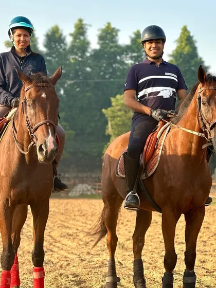 Two riders pose for a photo during their lesson. Learning to ride with a friend or partner is a great way to share the experience.