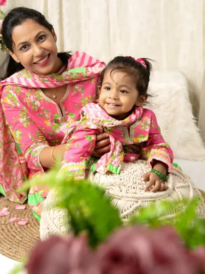 A mother and daughter share a sweet, smiling moment during their traditional-themed photoshoot.