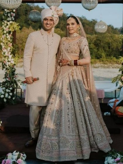 The couple standing together at the altar. The bride's entire look is a beautiful example of modern Indian bridal elegance.