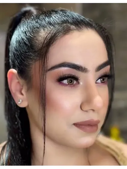 A close-up of a soft party makeup look. The subtle brown and pink tones on the eyes and lips create a warm and inviting style.