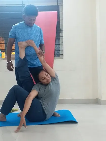 Hands-on adjustments are a key part of my teaching. Here, I am helping a student find the correct alignment in a seated twist. This personal guidance ensures you practice safely, understand the posture deeply, and get the most out of every movement.