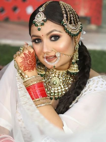 An elegant white and silver sequined lehenga, perfect for a reception or a modern bride. Paired here with a traditional chura and green beaded jewellery to create a beautiful contrast.