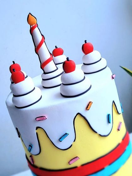 A close-up of the comic book style cake, showing the black outlines on the fondant details.