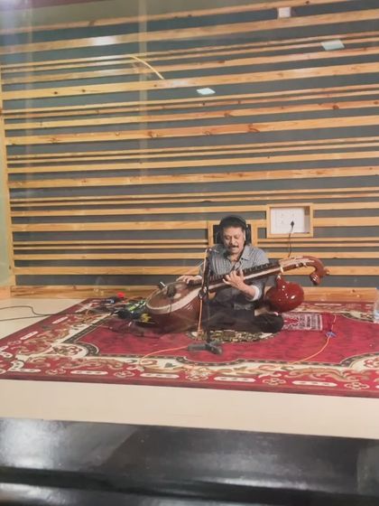 A snapshot of the Veena maestro Rajhesh Vaidhya in the studio, seated on a traditional rug. This image captures the blend of classical reverence and modern recording technology.