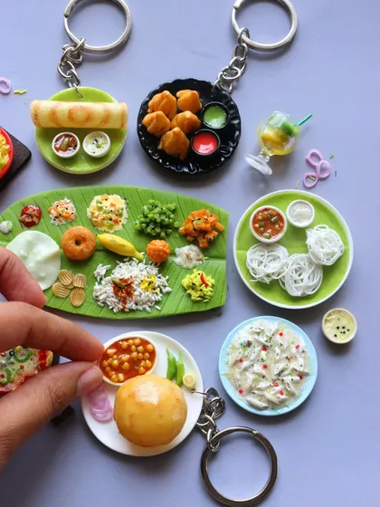 Carry your favourite food with you! I turn my miniatures into unique keychains, like these featuring a full South Indian thali, chole bhature, and idiyappam. They are a wonderful gift for any foodie.