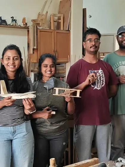 The joy of making things with your own hands. This group is all smiles with their newly built projects, including toy airplanes and storage boxes.