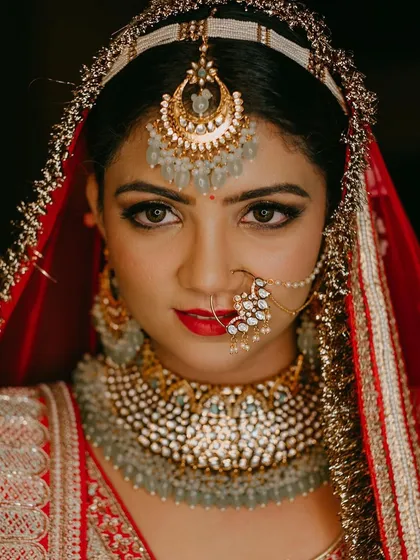 For the classic bride who dreams of a grand entrance, a bold red lip and defined eyes are timeless. This close-up shows how I balance a strong lip with radiant skin and shimmering gold eyeshadow for a truly regal North Indian bridal look.
