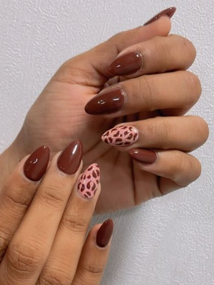 For the brown lover, a chic set with a glossy brown polish and a pink-based leopard print accent nail.