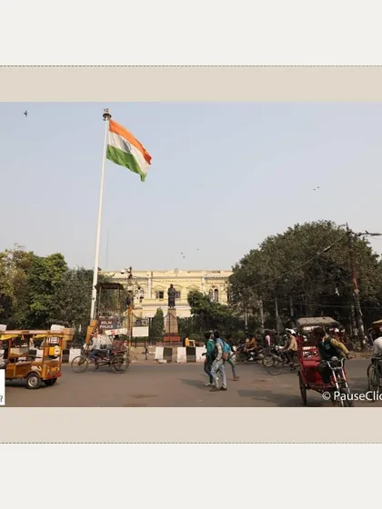 A wide shot of the Town Hall with the Indian flag, showing its location in the heart of a busy Old Delhi intersection.