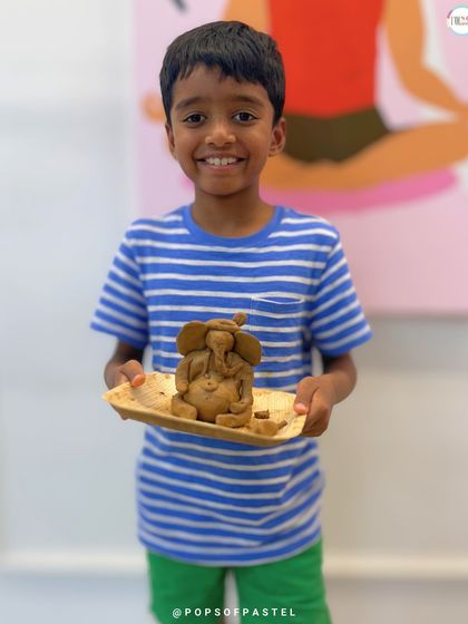 The pure joy on this young boy's face says it all. He's thrilled with the clay Ganesha he made all by himself.