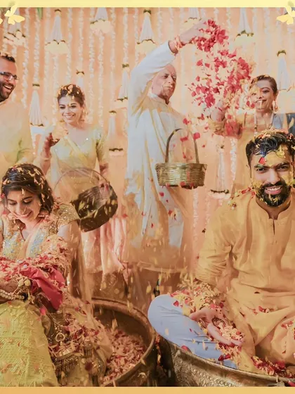 A beautiful family portrait in the midst of the Haldi celebrations, with everyone showering the couple with petals.