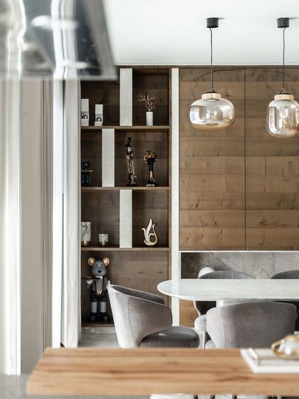 A closer look at the dining area in the Silhouette home. The wooden feature wall and shelving for curated objects add warmth and personality to the space, encouraging togetherness and connection.