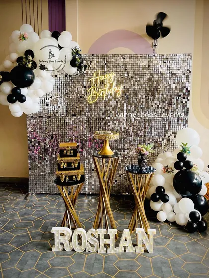 For a chic and modern milestone birthday, we designed this stunning silver sequin shimmer wall. The black and white balloon garland, custom marquee letters, and elegant dessert stands create a glamorous photo-op for any adult celebration.