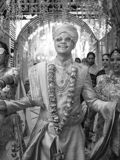 The groom's joyful entrance, full of energy and style. This black and white shot captures the excitement of the Baraat.