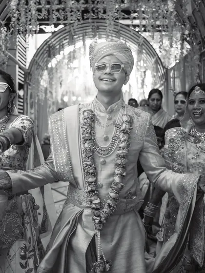 The groom's joyful entrance, full of energy and style. This black and white shot captures the excitement of the Baraat.