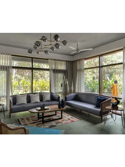 The living area in the Nairy Residence is designed to be immersed in the garden. Expansive floor-to-ceiling windows erase the boundary to the outdoors, filling the space with light and offering uninterrupted views of the surrounding greenery, creating a tranquil atmosphere.