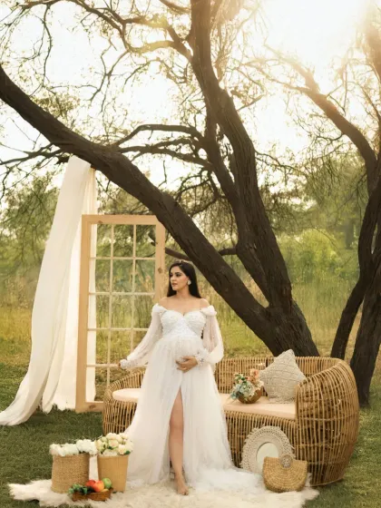 We love creating beautifully styled outdoor settings that reflect your personality. This boho-chic setup, complete with a wicker sofa and floral arrangements, shows how we can design a unique and picturesque scene for your maternity photoshoot.