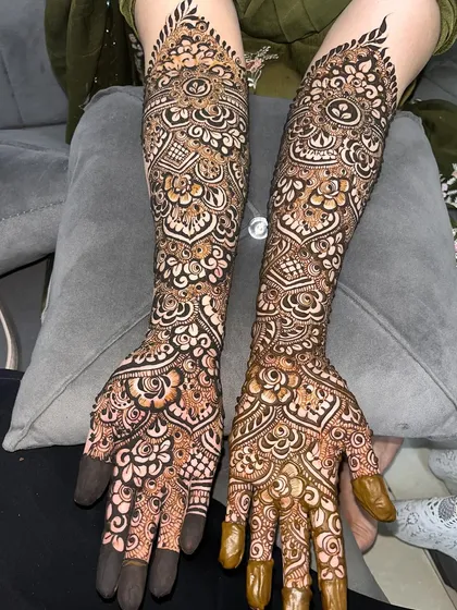 A closer look at the detailed bridal henna for Tuba, showcasing the fine lines and shading on her hands and arms.