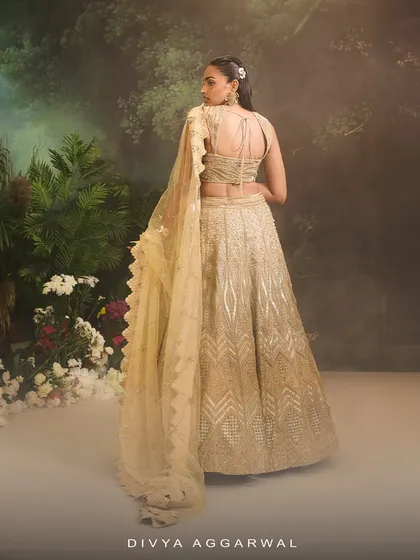 The back of the Jade Lehenga Set, showing the delicate tie-up detail of the blouse and the continuous flow of the heavily embellished ombre pattern.