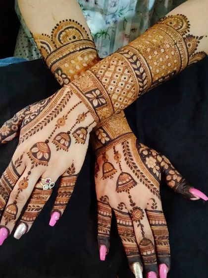 This stylish mehandi features hanging jhumki (earring) motifs. The design is perfect for a festive party or a sangeet night.