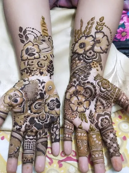 A gorgeous floral design for a guest. The pattern is dense on the palm and fingers, with a lighter floral vine extending up the arm.