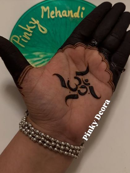 A clear, colored view of the "Om" symbol mehndi. The deep, black stain of the organic henna makes this sacred symbol stand out beautifully.