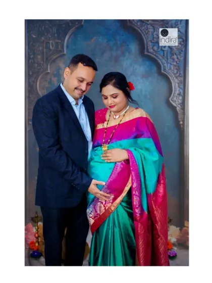 A classic couple's portrait with the husband standing beside his wife, both gently touching the baby bump in a moment of shared love.