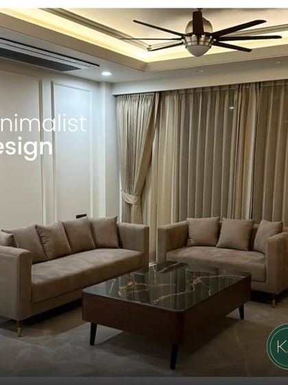 This living room setup embodies minimalist design with its clean-lined beige sofas and a dark marble-topped coffee table. The simplicity of the forms is balanced by the richness of the materials, creating a space that is both modern and warm.