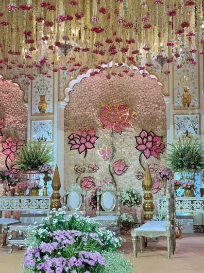 A beautiful angle of the mandap, showcasing the blend of floral walls, hanging blooms, and traditional metallic decor elements that define our signature style.