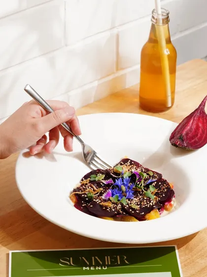 A beautifully plated beetroot carpaccio from the summer menu, styled to look light, fresh, and artistic.