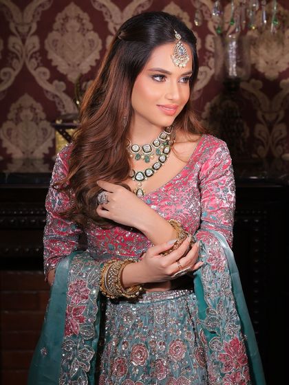 A beautiful, soft smile from a wedding guest. The makeup is glamorous but not overpowering, with a focus on radiant skin and defined eyes.